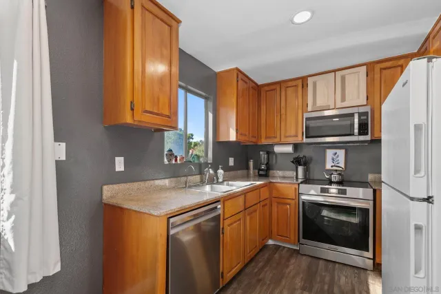 a kitchen with stainless steel appliances granite countertop a sink stove and microwave