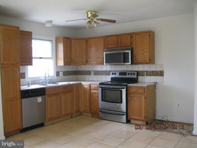 9239 Fowler Lane Lanham, MD 20706 - Photo 7 of 17 a kitchen with stainless steel appliances granite countertop a stove a sink and a microwave