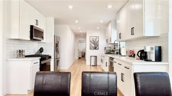 a kitchen with white cabinets and white appliances