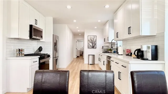 a kitchen with white cabinets and white appliances