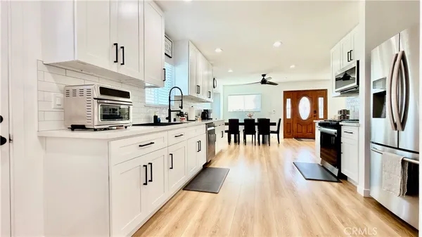 a kitchen with stainless steel appliances granite countertop a sink a stove and cabinets