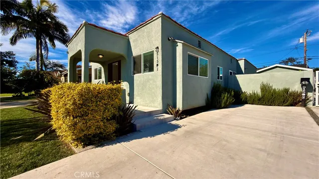 a view of a house with a yard and potted plants