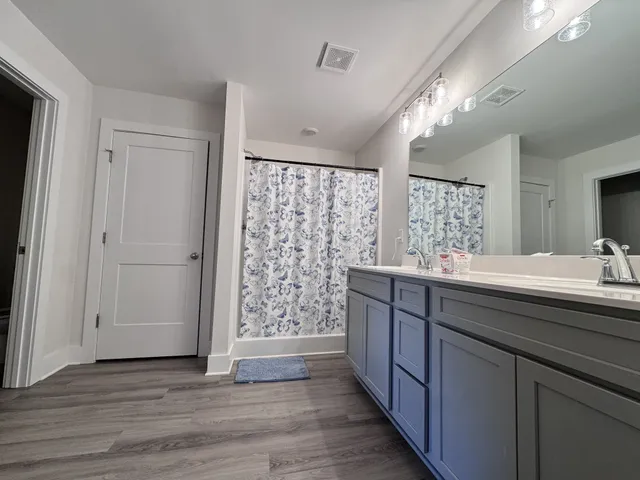 a bathroom with a double vanity sink and mirror with shower