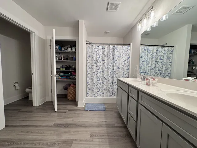 a bathroom with a double vanity sink a large mirror and a shower