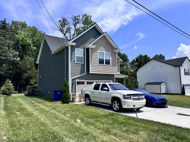 a front view of a house with a garden and parking
