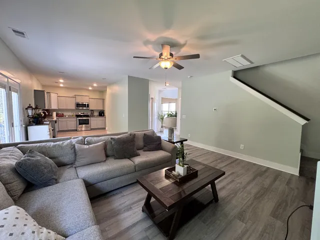 a living room with furniture and wooden floor