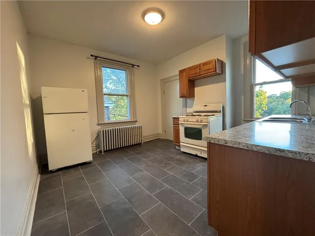a kitchen with granite countertop a refrigerator and a sink