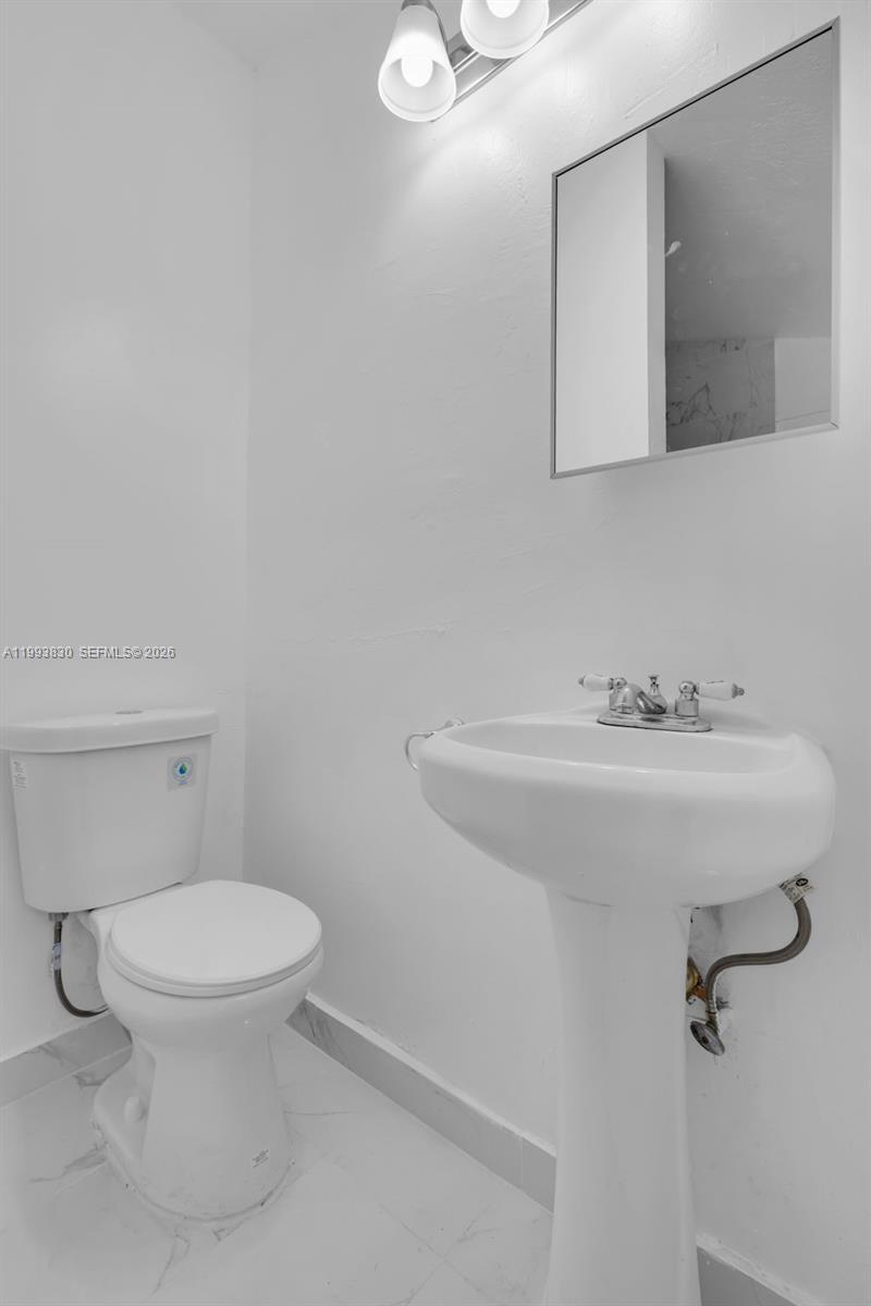 6295 Southwest 29th Street, Unit 1 Miami, FL 33155 - Photo 12 of 15 a bathroom with a sink a toilet and mirror