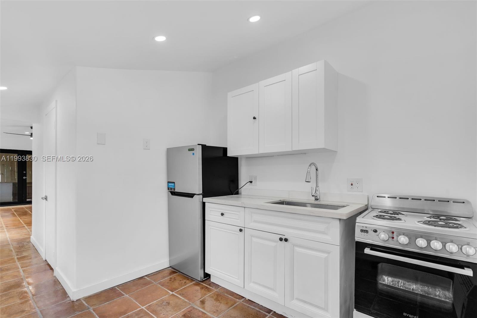6295 Southwest 29th Street, Unit 1 Miami, FL 33155 - Photo 9 of 15 a kitchen with a sink stove and refrigerator