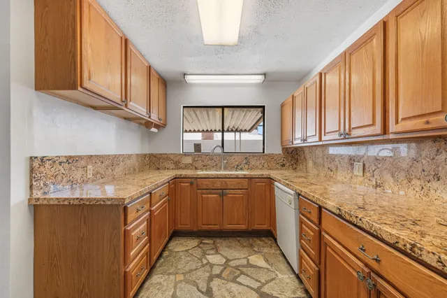 a kitchen with stainless steel appliances granite countertop a sink stove and cabinets