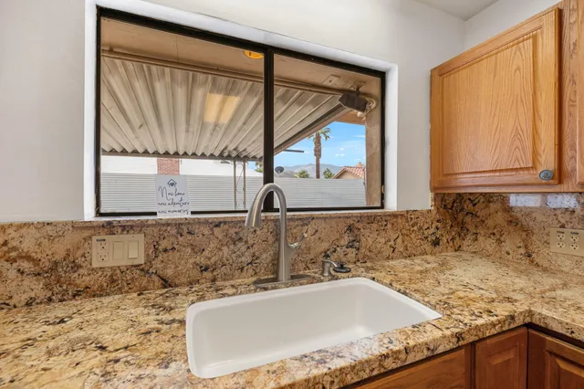 a bathroom with a granite countertop sink and a large mirror