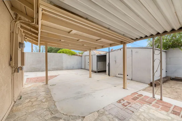 a view of a backyard with chairs and a potted plant