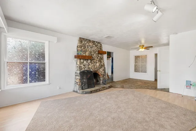 an empty room with windows and fireplace