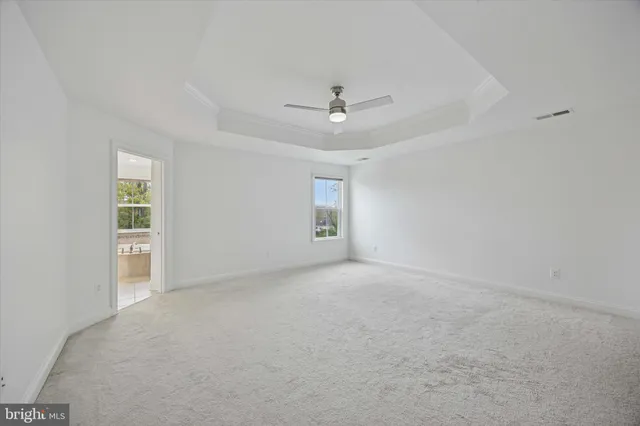 an empty room with a ceiling fan and a window