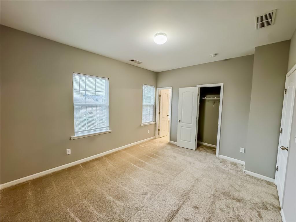 1218 Park Pass Way Suwanee, GA 30024 - Photo 19 of 23 an empty room with windows and closet