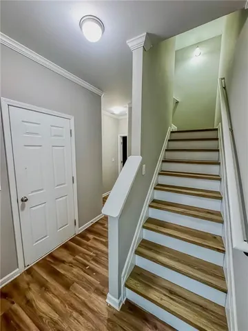 a view of a hallway with wooden floor and stairs