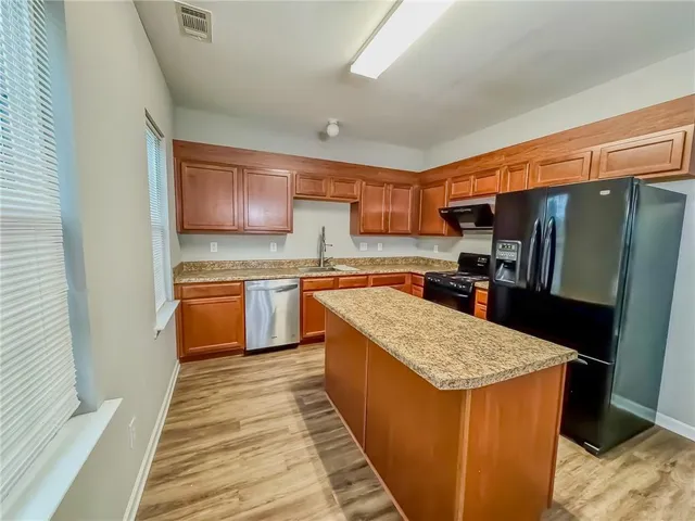 a kitchen with stainless steel appliances granite countertop a stove top oven a sink and dishwasher