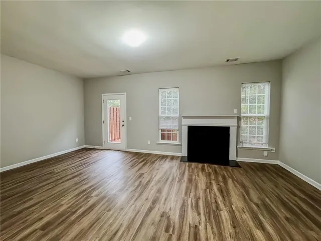 a view of empty room with wooden floor and fireplace