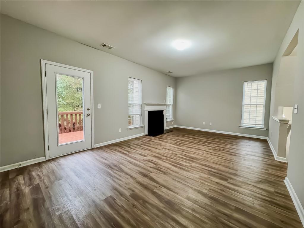 1218 Park Pass Way Suwanee, GA 30024 - Photo 10 of 23 an empty room with wooden floor and windows
