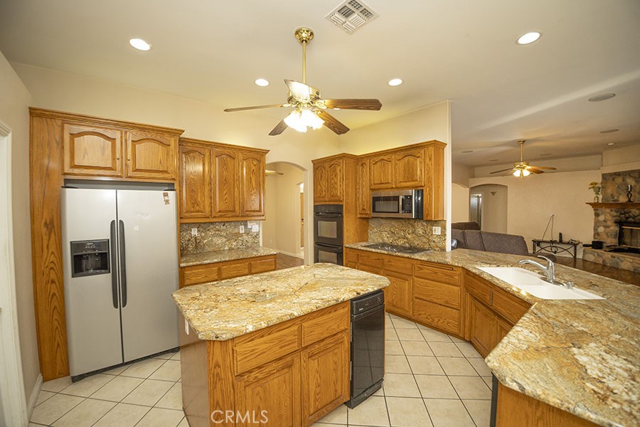 11830 Joshua Dell Road Victorville, CA 92392 - Photo 22 of 48 a large kitchen with kitchen island a large counter top space appliances and cabinets