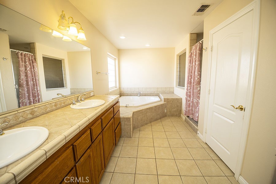 11830 Joshua Dell Road Victorville, CA 92392 - Photo 28 of 48 a bathroom with a double vanity sink mirror and bathtub