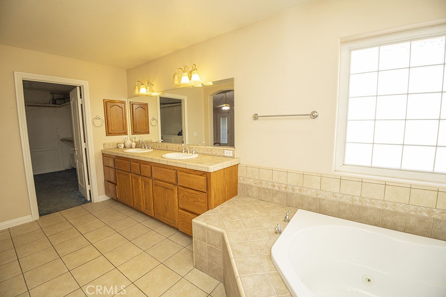 11830 Joshua Dell Road Victorville, CA 92392 - Photo 30 of 48 a bathroom with a tub sink and mirror