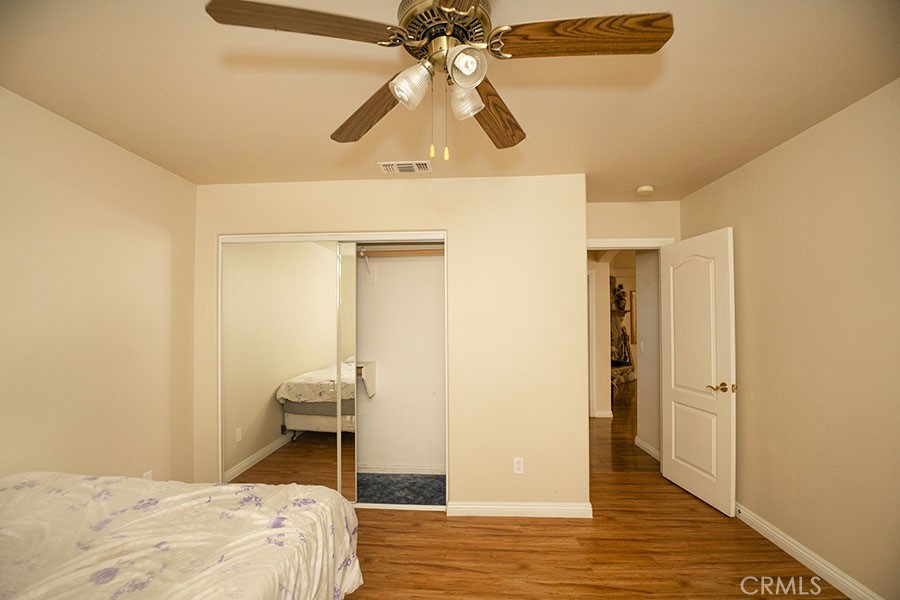 11830 Joshua Dell Road Victorville, CA 92392 - Photo 33 of 48 a bedroom with a bed and a chandelier