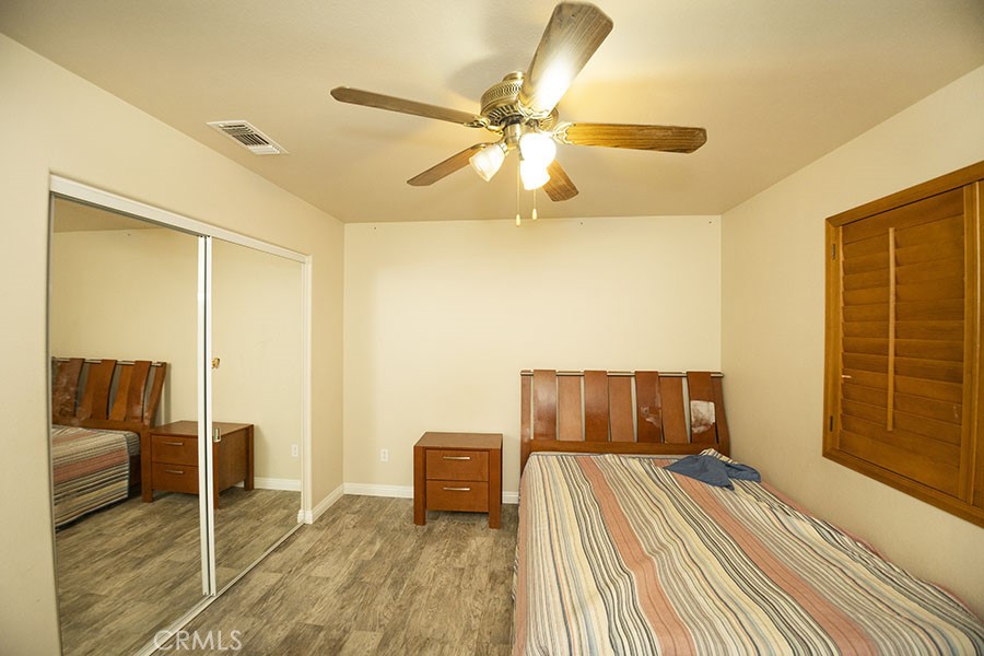 11830 Joshua Dell Road Victorville, CA 92392 - Photo 37 of 48 a bedroom with a bed and wooden floor