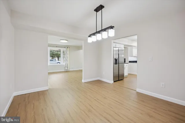 a view of empty room with wooden floor and windows