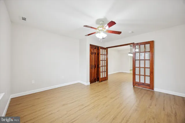 a view of an empty room with window and wooden floor