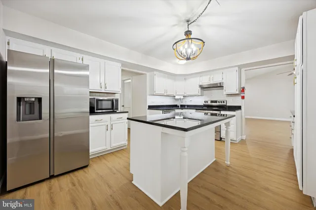 a kitchen with stainless steel appliances a refrigerator and a stove top oven