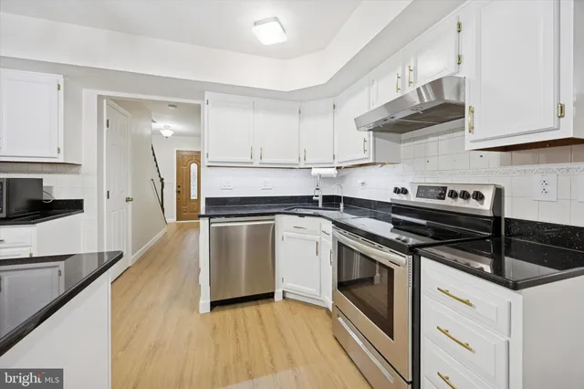 a kitchen with cabinets and stainless steel appliances