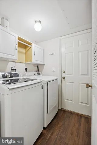 a utility room with cabinets washer and dryer