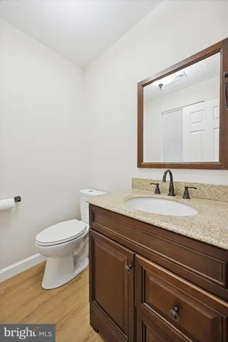 a bathroom with a granite countertop sink a toilet and a mirror