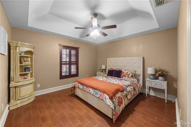 a bedroom with a bed wooden floor and window