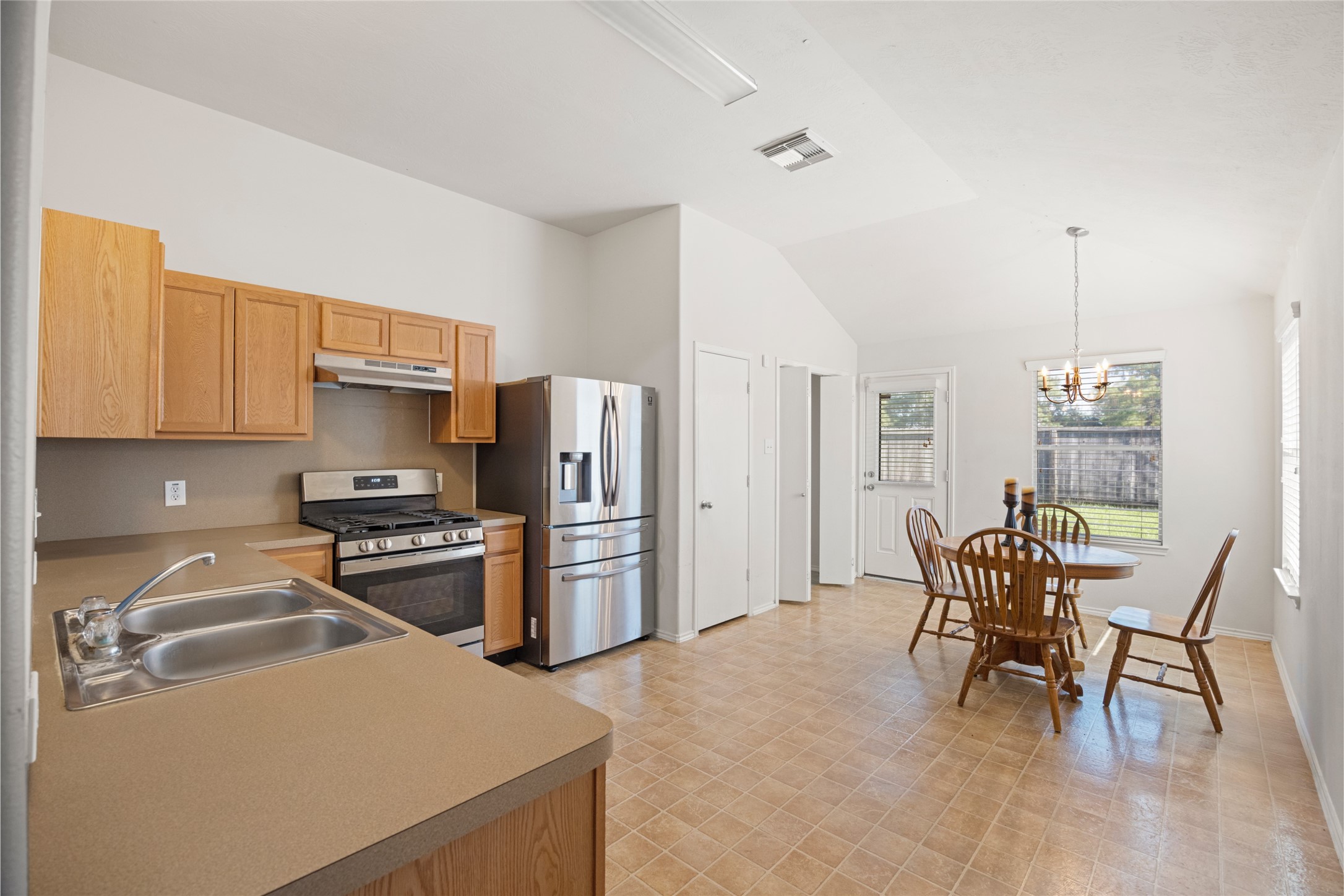 15926 Colonial Bridge Lane Houston, TX 77073 - Photo 11 of 27 a kitchen with stainless steel appliances kitchen island granite countertop a table chairs and a refrigerator