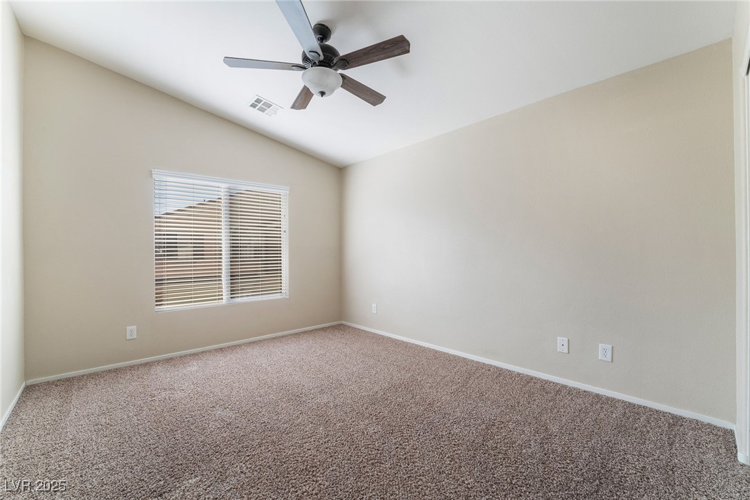1570 Rusty Ridge Lane Henderson, NV 89002 - Photo 31 of 35 Carpeted empty room featuring ceiling fan, baseboards, lofted ceiling, and visible vents