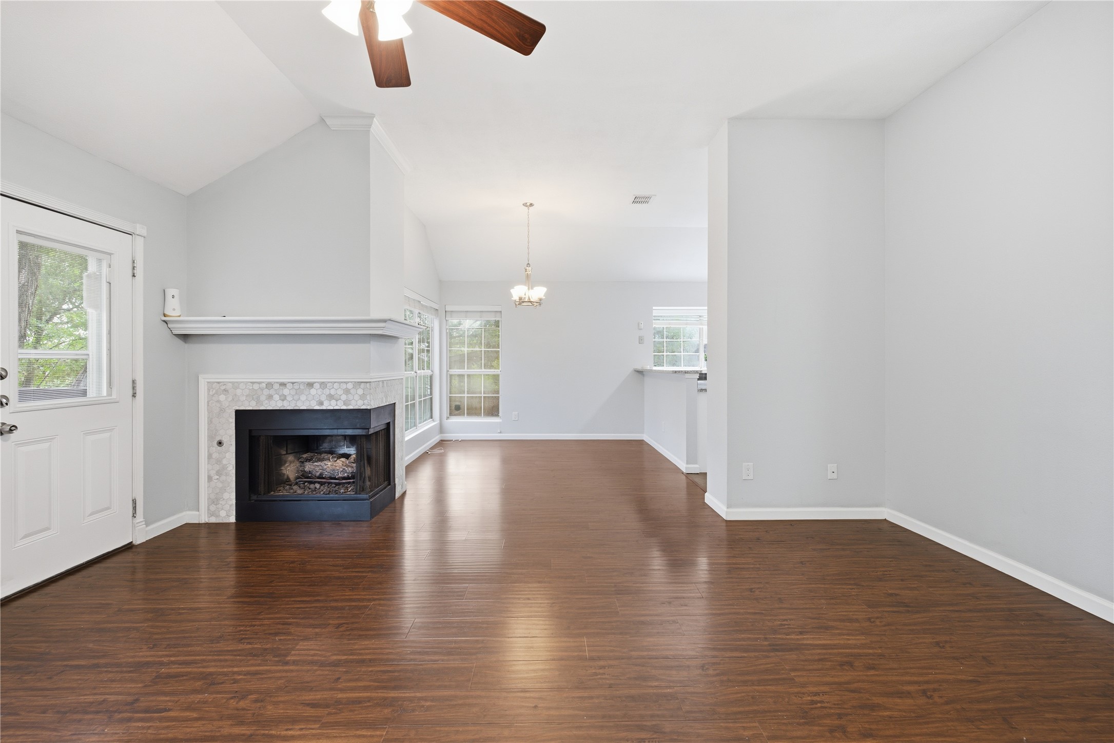 2922 Wickersham Lane Austin, TX 78741 - Photo 21 of 26 an empty room with wooden floor fireplace and window