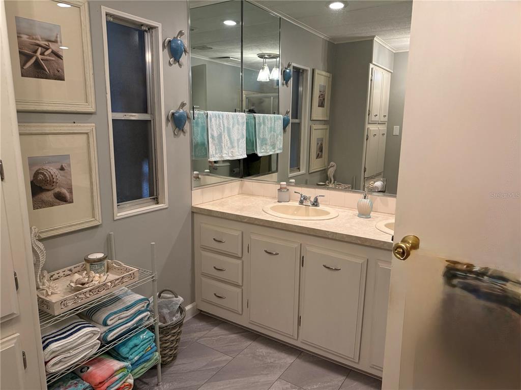 8010 Highpoint Boulevard Brooksville, FL 34613 - Photo 15 of 32 a bathroom with a double vanity sink and a mirror