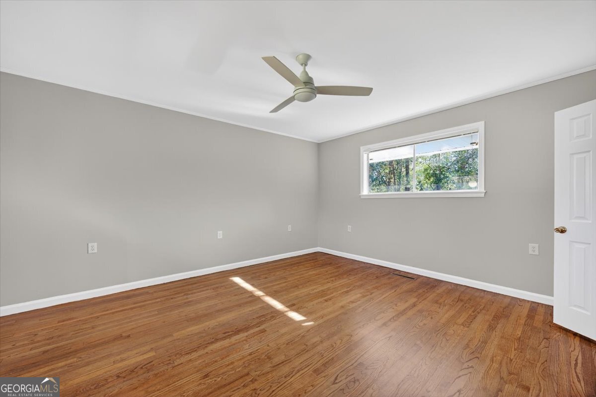 4555 Old Club Road Macon, GA 31210 - Photo 26 of 38 an empty room with wooden floor ceiling fan and windows