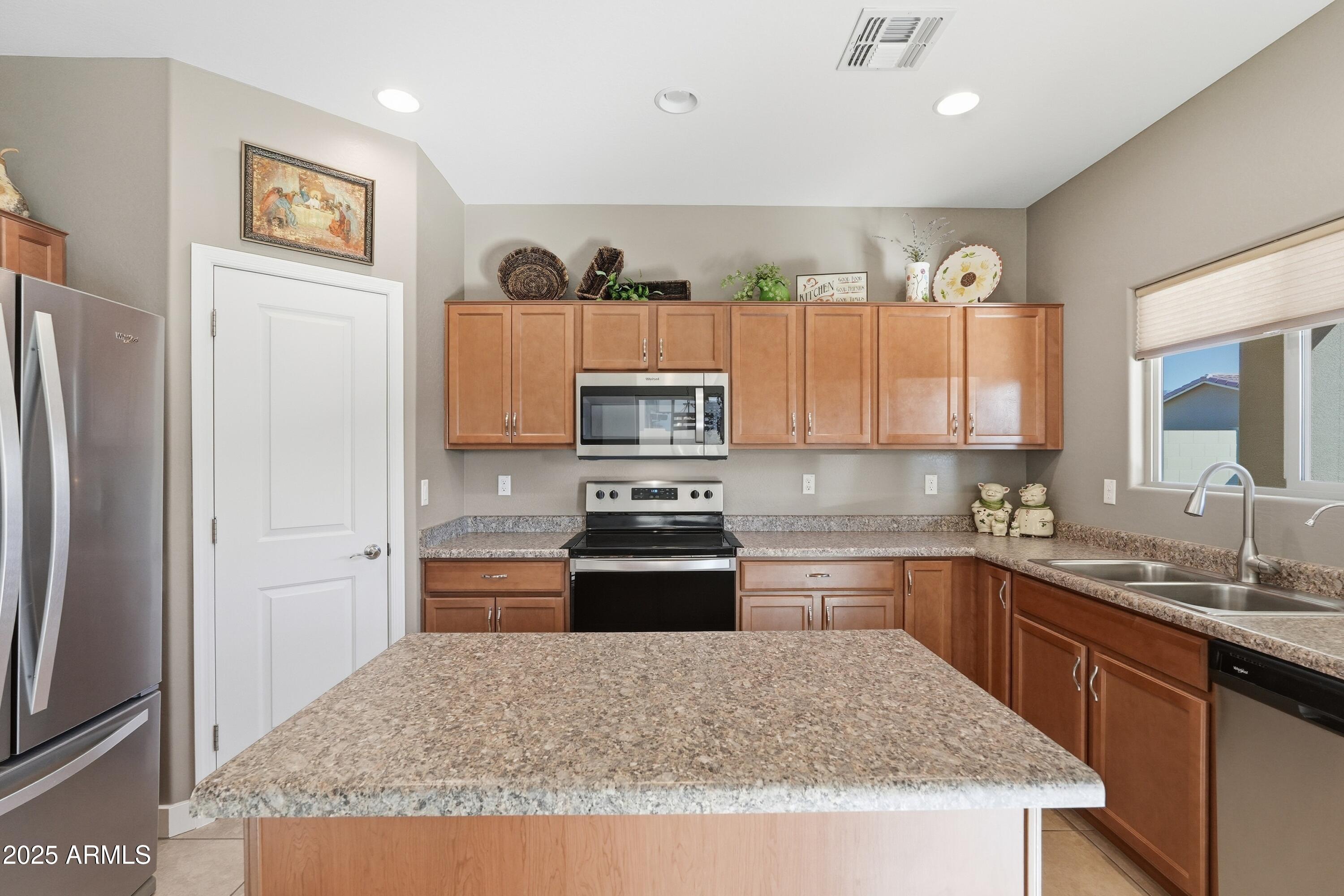 1815 South Hayley Road Apache Junction, AZ 85119 - Photo 11 of 33 a kitchen with kitchen island granite countertop a refrigerator stove and sink