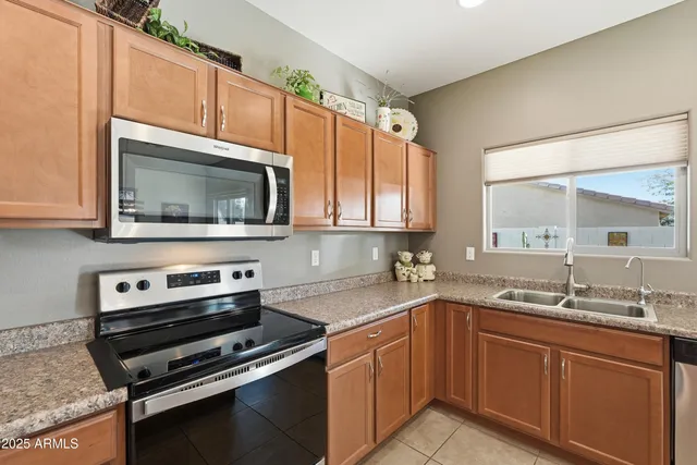 a kitchen with kitchen island granite countertop a refrigerator stove and sink