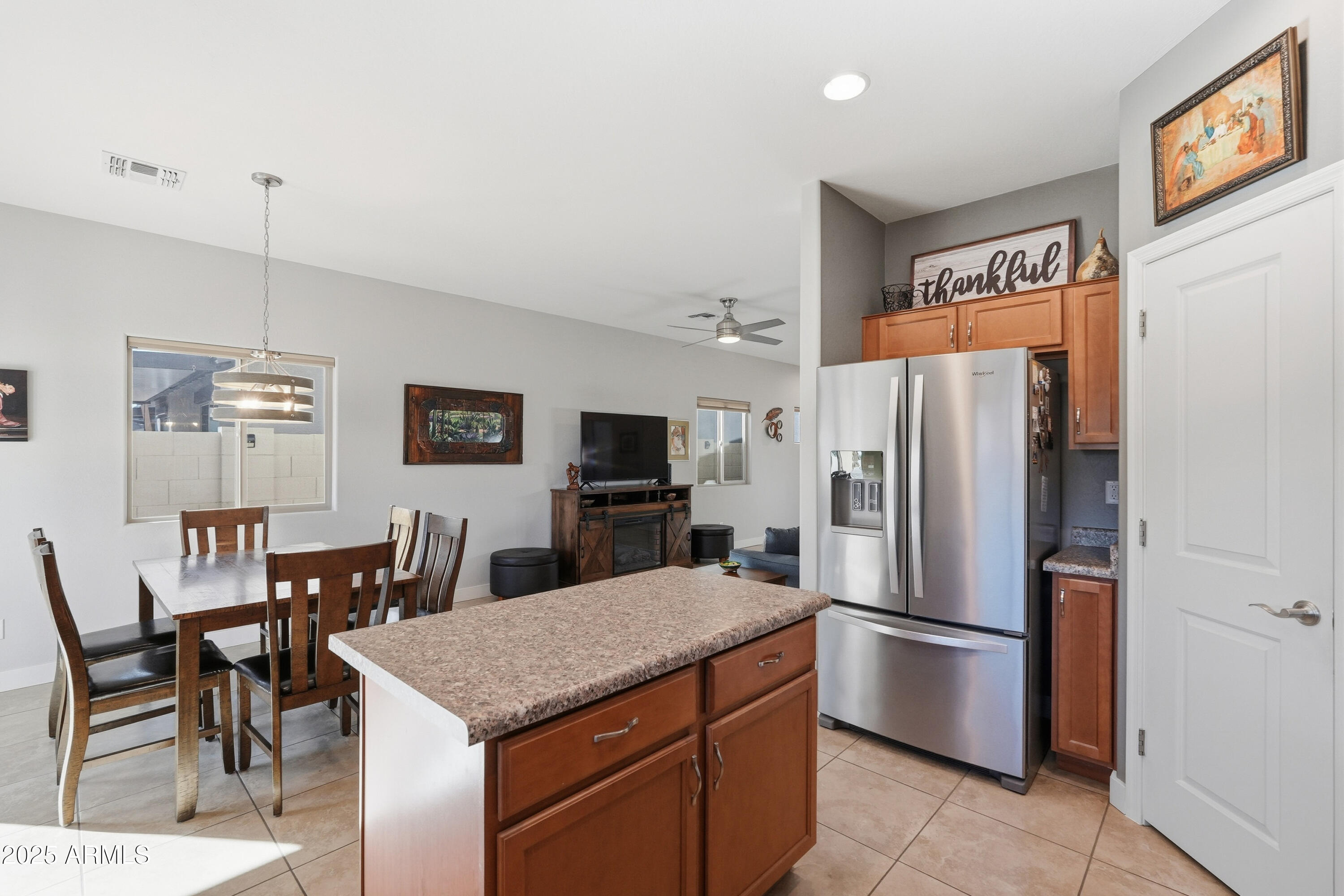 1815 South Hayley Road Apache Junction, AZ 85119 - Photo 9 of 33 a kitchen with stainless steel appliances a refrigerator a stove a dining table and chairs with wooden floor