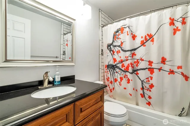 a bathroom with a sink a toilet and a shower curtain