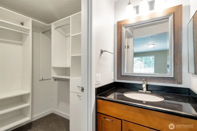 a bathroom with a granite countertop sink and a mirror