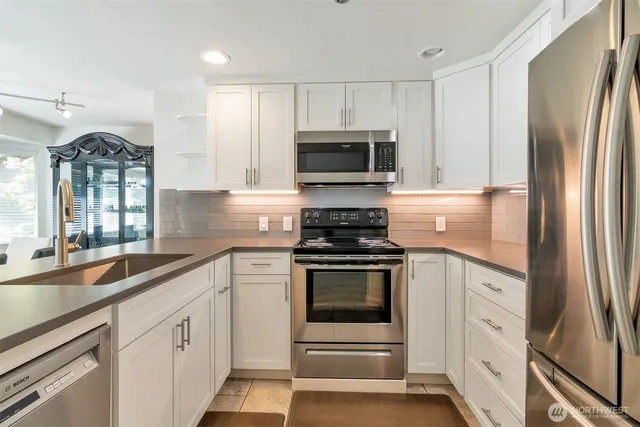 a kitchen with white cabinets stainless steel appliances and sink