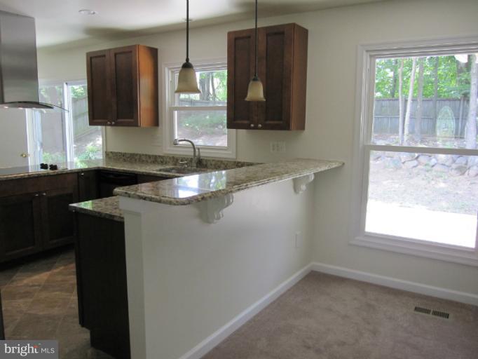 a kitchen with a sink a window and cabinets