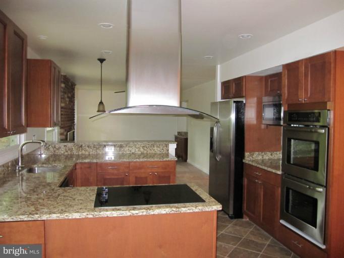 3240 Birchtree Lane Silver Spring, MD 20906 - Photo 15 of 19 a kitchen with stainless steel appliances granite countertop a sink and a refrigerator