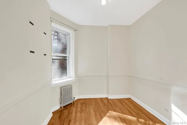 a view of a bedroom with wooden floor and cabinet