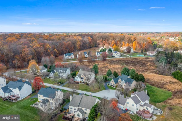 a front view of a house with a garden and trees